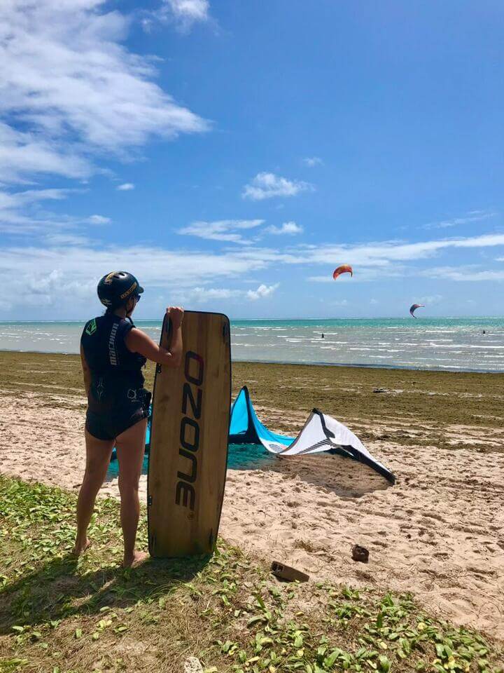 Aluna com prancha na praia